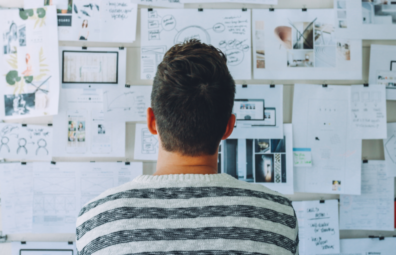 Person looking at various plans on a wall to guide them through a process
