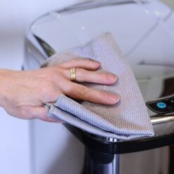 Person Cleaning Stainless Steel Bin with cloth