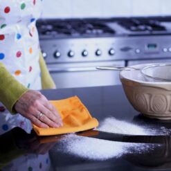 Wiping kitchen surface with orange cloth