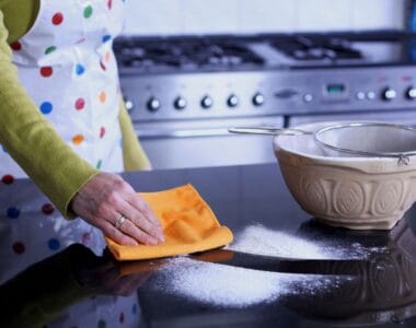 Wiping kitchen surface with orange cloth